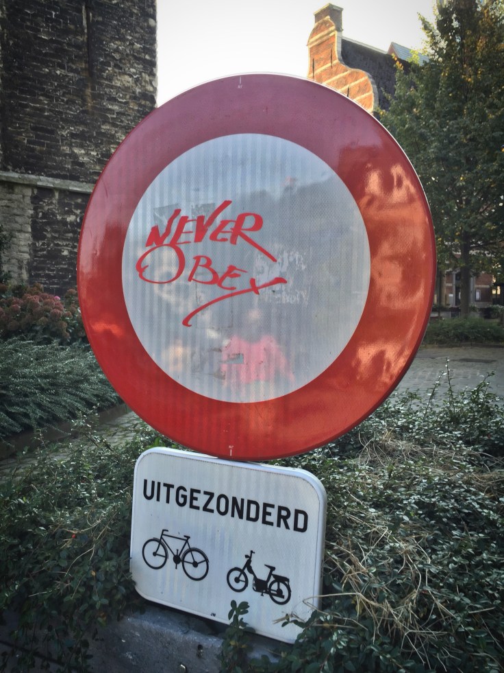 Teken aan de wand #65 Never Obey. Leuven, Halfmaartstraat, 11 oktober 2015, Foto Hendrik Elie Vanden Abeele. Te Voet in de Stad